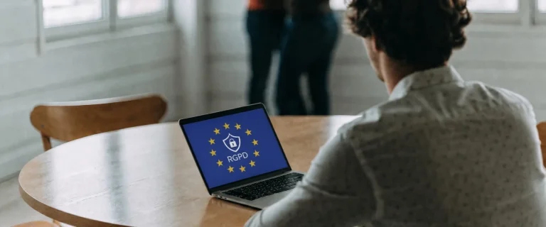 Persona ante un portátil con el emblema del RGPD en la pantalla