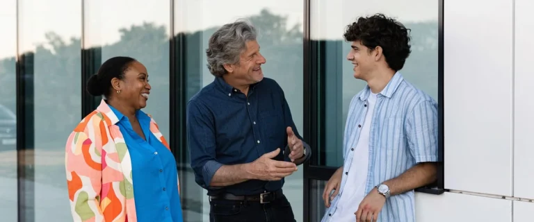 Tres personas conversando en la entrada de un centro formativo